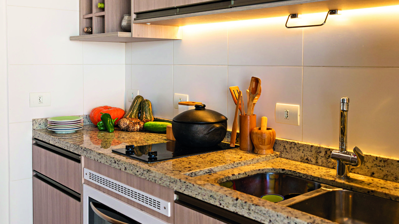Embutida nos armários, uma fita de LED garante mais iluminação na hora de cozinhar. 