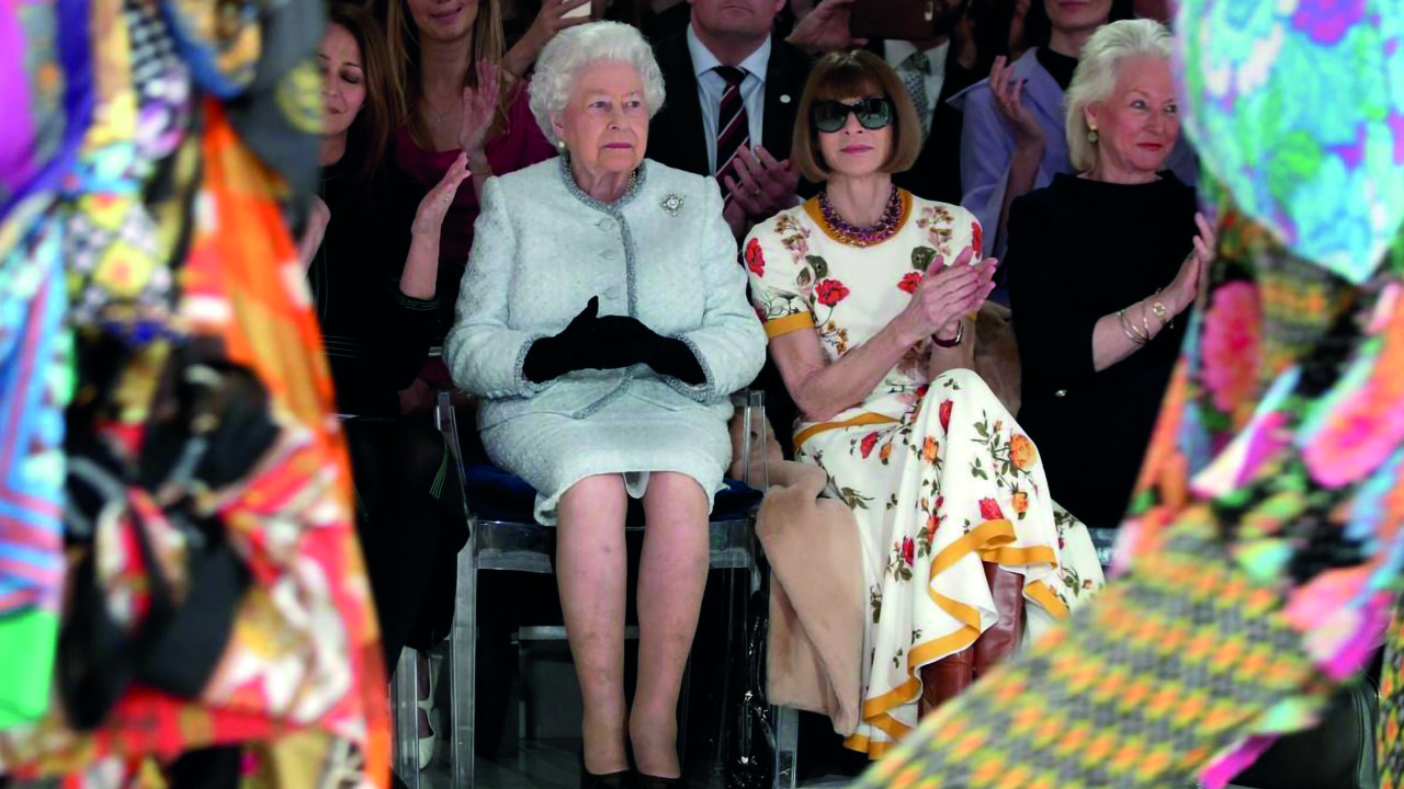 Rainha Elizabeth 2ª sentada em uma Louis Ghost durante desfile de moda de  Richard Quinn