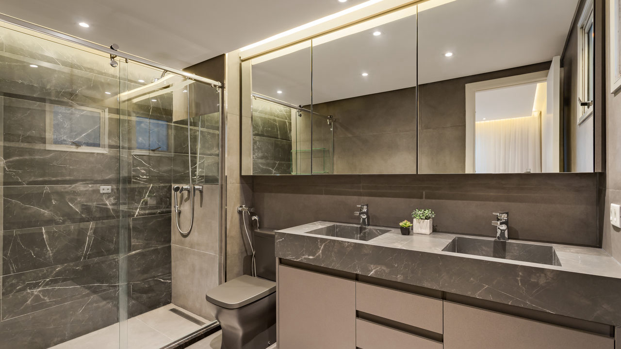 O banheiro do casal é composto por revestimentos e louças em tons de cinza, para criar um ambiente mais sóbrio.