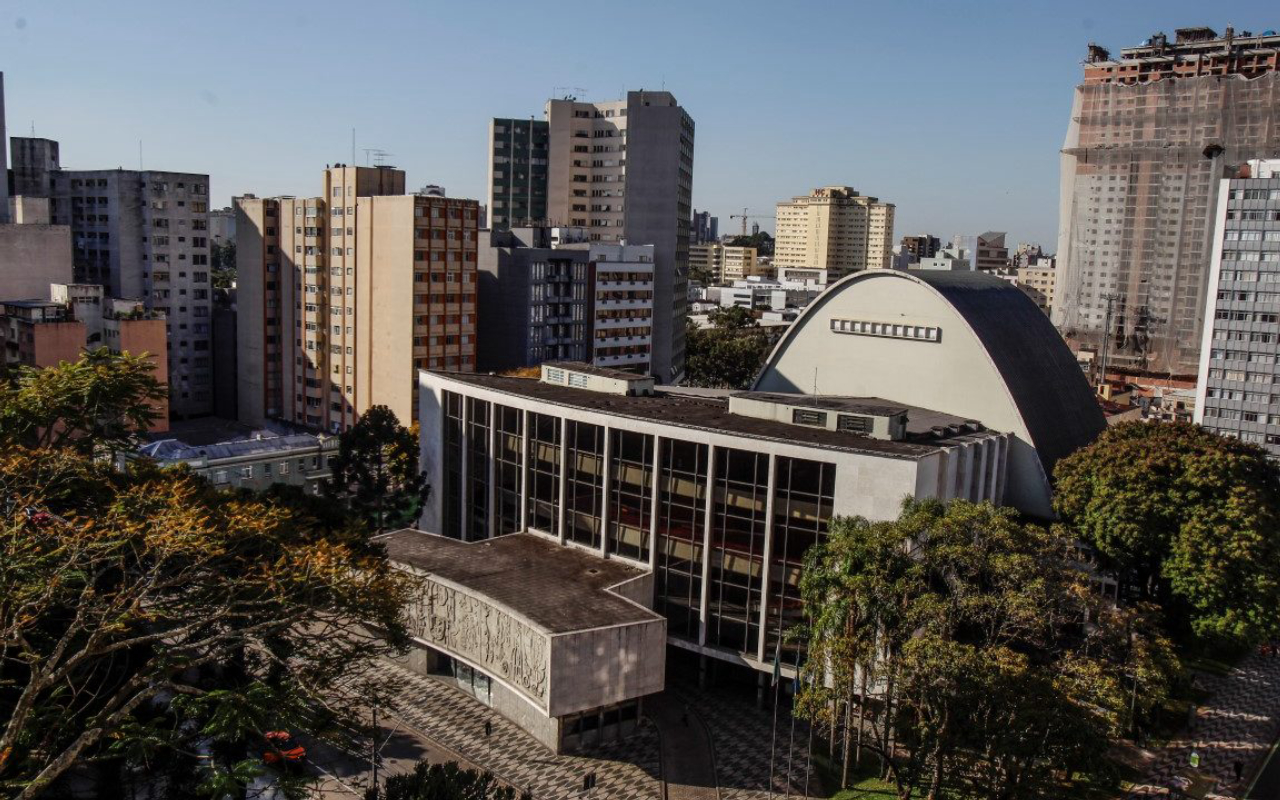 Vista aerea da Praça Santos Andrade arborizada, teatro Guaira e os predios do centro de Curitiba