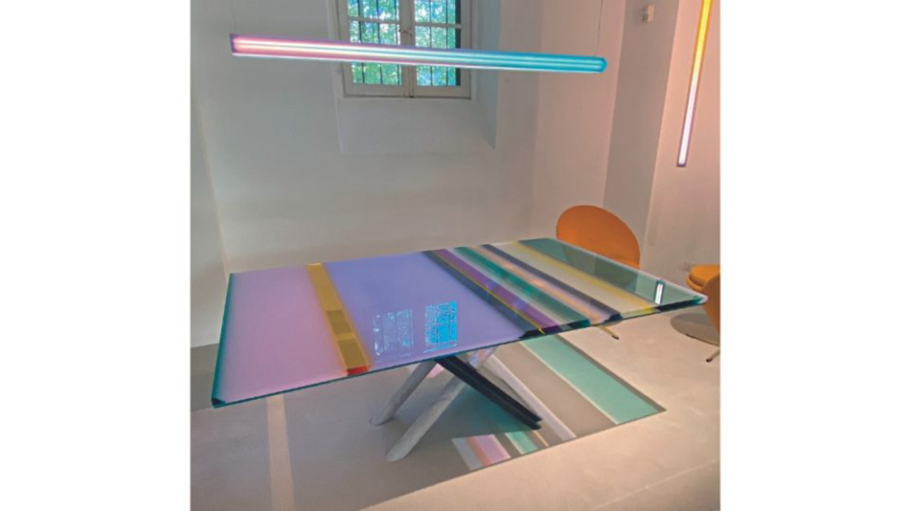 Para a mesa Rainbow, a artista Vasa Mihich recuperou uma base em mármore desenhada por Maurizio Cattelan nos anos 1980 e a compôs com a resina em acrílico em faixas coloridas no tampo. O design foi desenvolvido para a Draga &amp; Aurel.