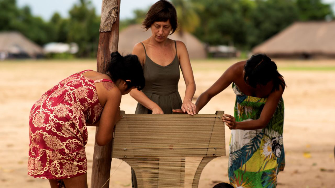 Produção das capas para a cadeira Paulistano pela população indígena da aldeia Kamayura . 