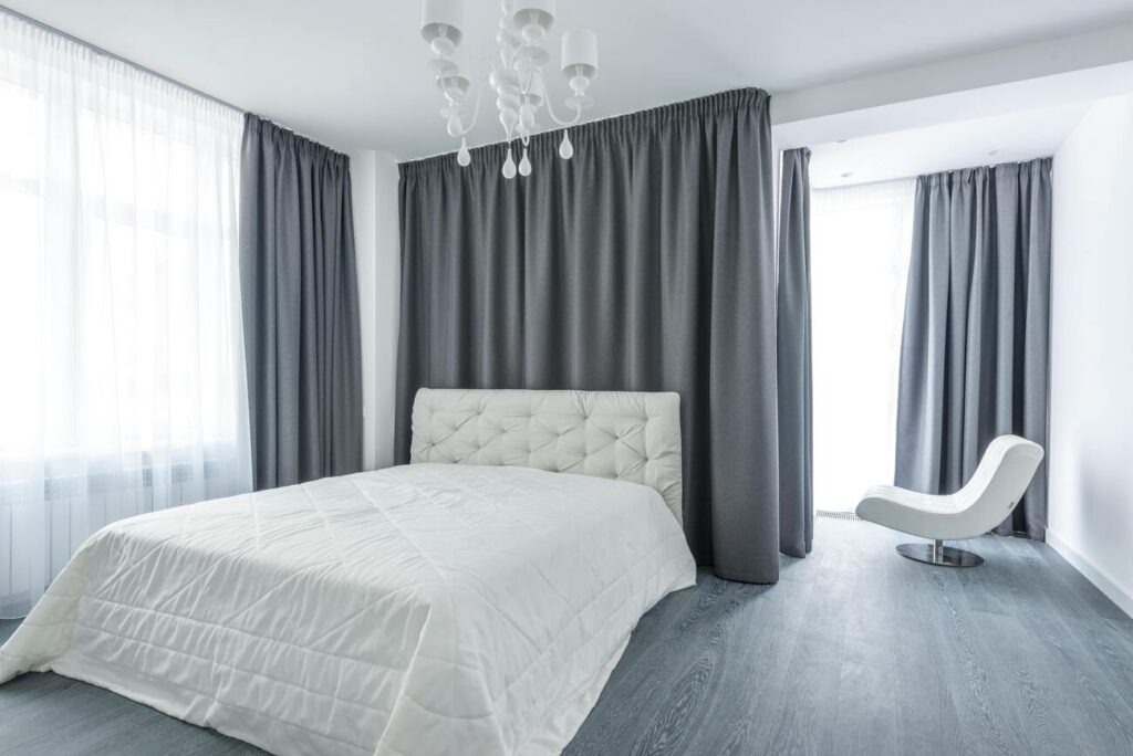 O porcelanato acetinado cinza combinado com uma cama branca cria um ambiente sereno e elegante, perfeito para uma boa noite de sono | Pexels