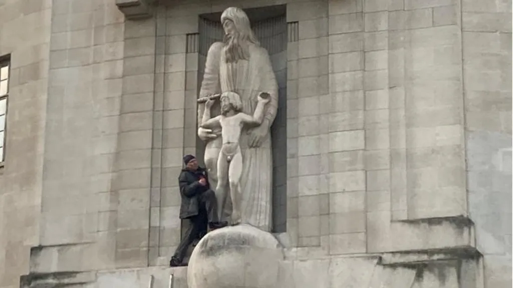 Um homem ataca uma escultura de Eric Gill com um martelo em frente à BBC, Londres, 2022. | Fonte da imagem: BBC News