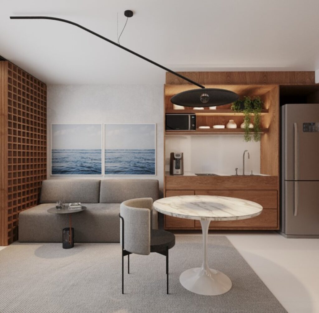 O sofá-cama e a mesa de refeições convivem com a cozinha compacta. Projeto: Estúdio FJ.