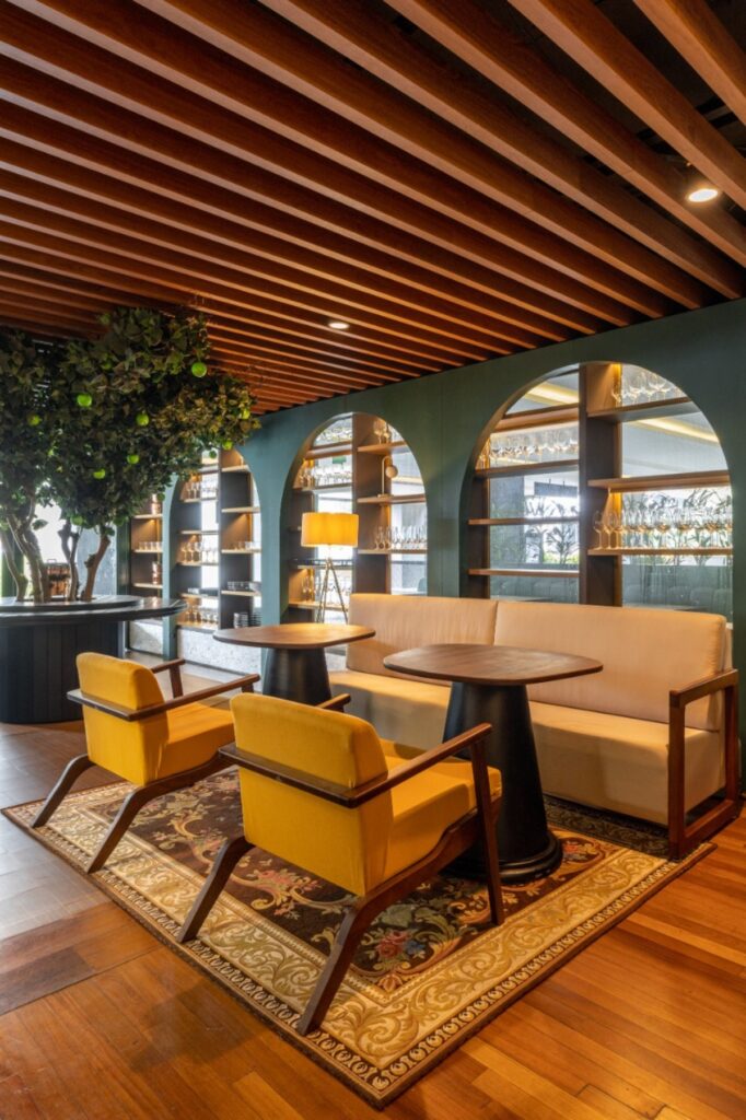 O canto de permanência com poltronas amarelas e a árvore traz o toque biofílico. Projeto: Ultra Arquitetura.