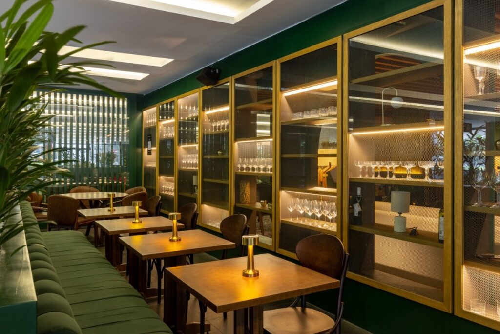 As estantes metálicas iluminadas servem como divisórias e exposição. Projeto: Ultra Arquitetura.