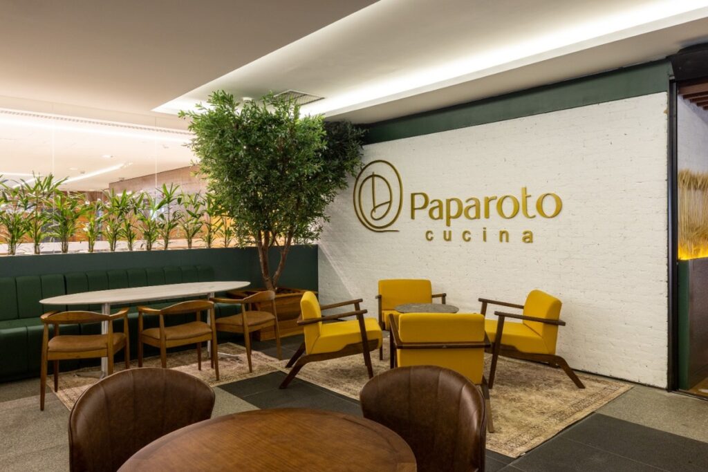 A identidade visual aplicada à parede principal reforça a marca. Projeto: Ultra Arquitetura.