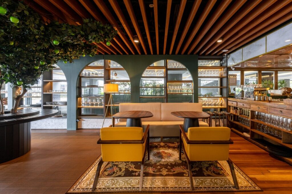 O espaço de espera ou lounge utiliza estantes arqueadas e cores neutras para criar um ambiente acolhedor. Projeto: Ultra Arquitetura.