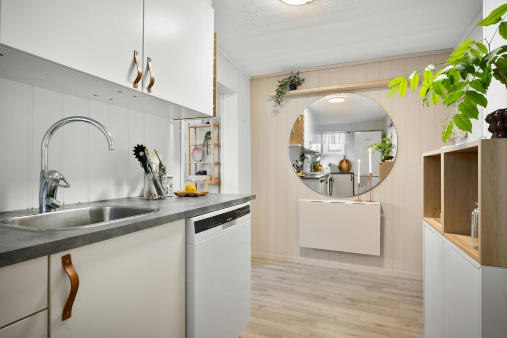 Uma paleta nórdica e arejada. O branco e a madeira clara dominam, criando leveza. Detalhes em couro caramelo e cinza grafite adicionam textura e contrastes sutis, típicos do design escandinavo. Fonte: Unsplash