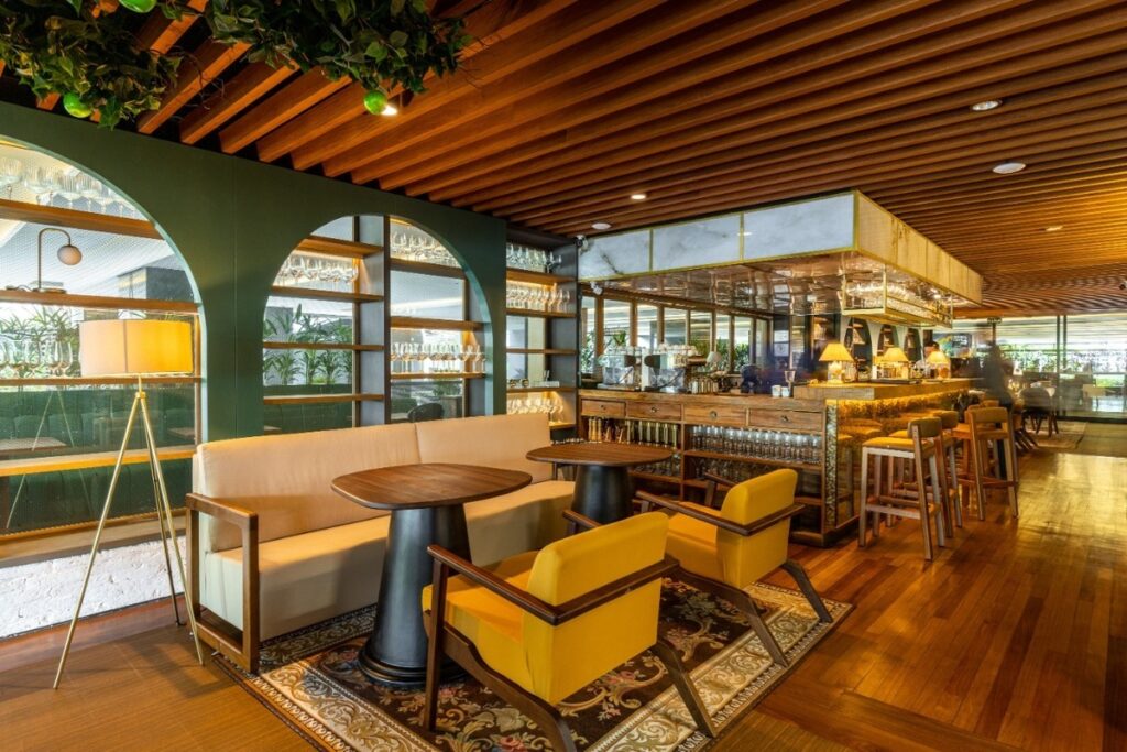 A área de convivência combina o aconchego do teto e piso de madeira com a ousadia das poltronas amarelas do Restaurante Paparoto Cucina em SP. Projeto: Ultra Arquitetura